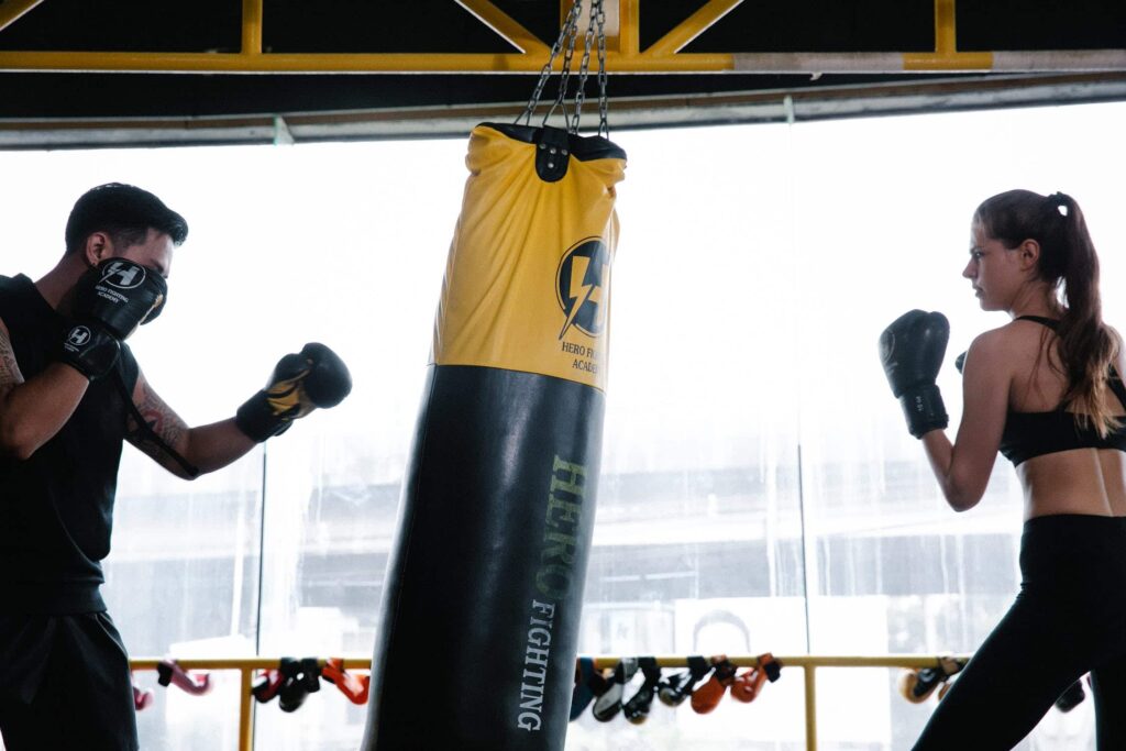 a couple sparring with custom a punching bag
