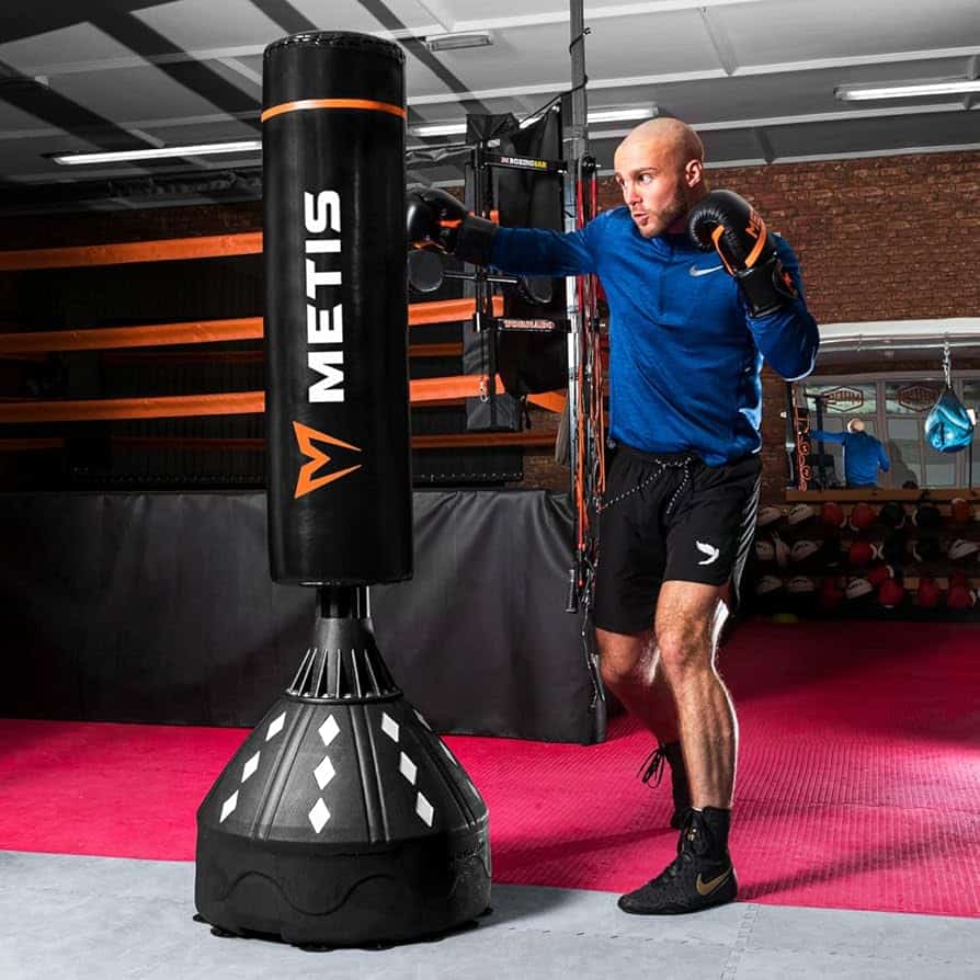 A man trying to hit a freestanding punching bag, one of the types of punching bags.