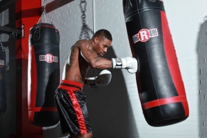 A man hitting a punching bag at a gym.