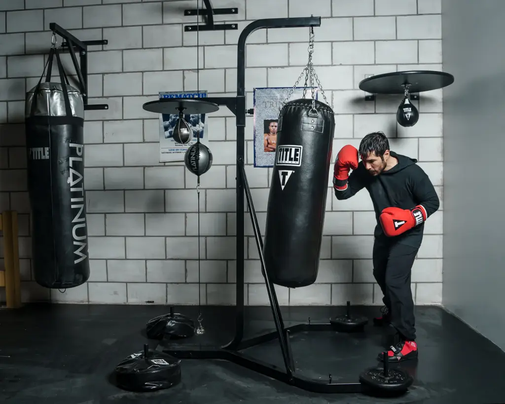 A man trying to hit a punching bag at a gym.