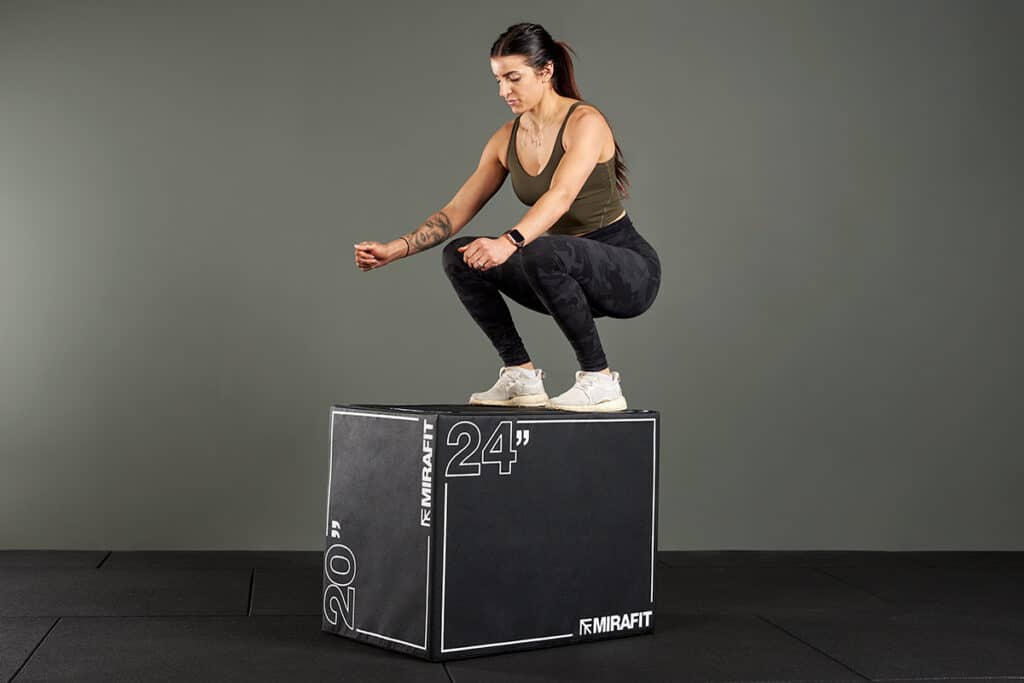 A woman on a jump box, ready for a jump box workout.