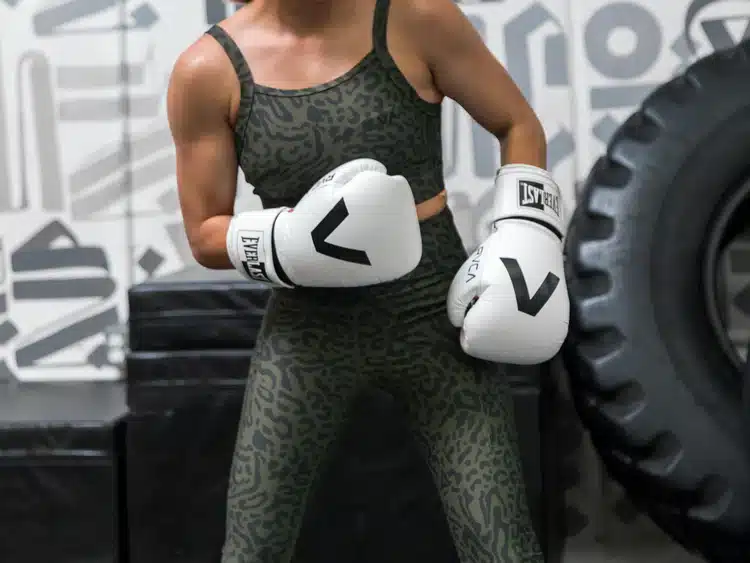  woman with a pair of professional boxer's glove ready to punch