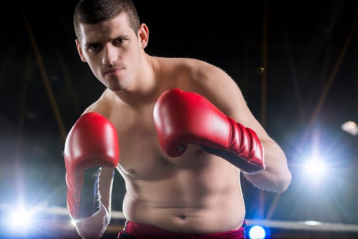 Young boxer in fighting stance looking at camera with the best box gloves