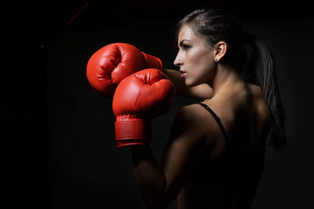 Women facing sideways wearing red women's boxing gloves